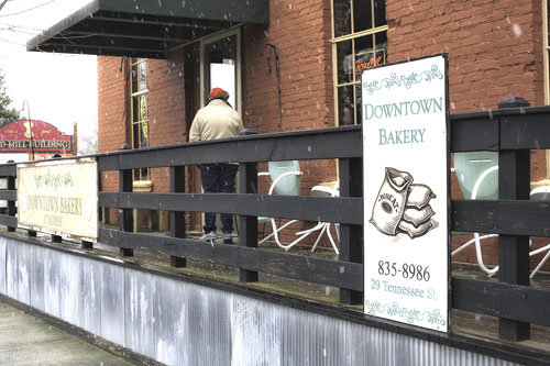 Downtown Bakery owner and baker, Kate Simmons, enjoys a brief break outside during an unexpected snowfall before returning to work.
