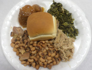 All plates include collards, black-eyed peas, candied yams, and barbecue with a roll. (Ray Linville) 