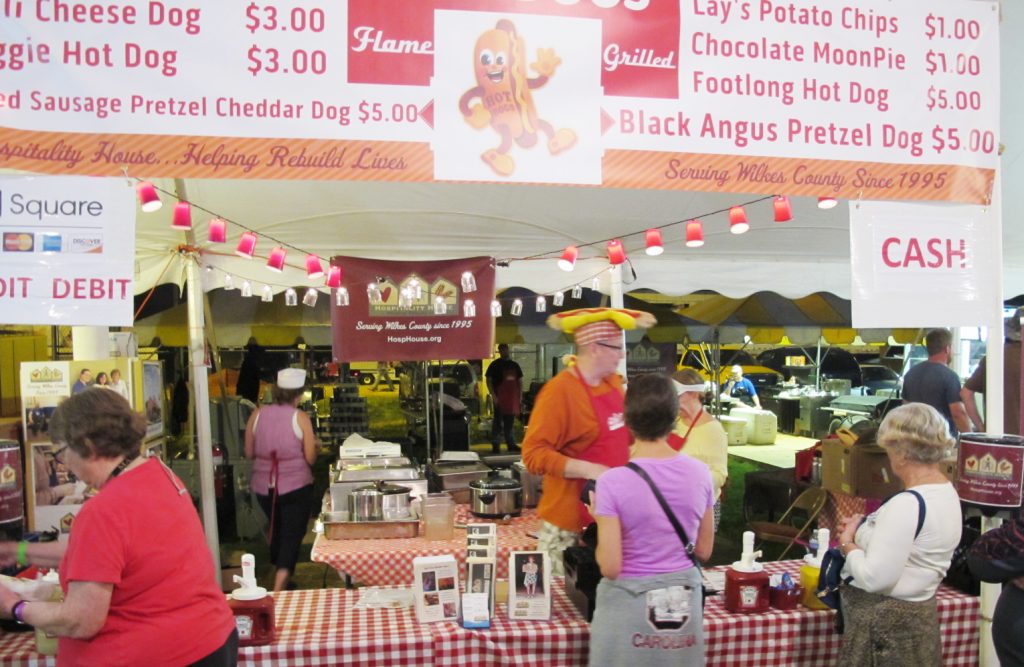 Dressing dogs at the Hospitality House gourmet hot dog booth.