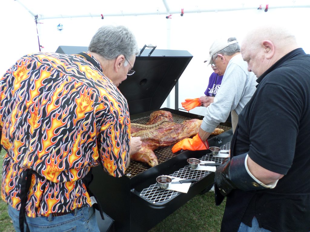 Judges begin their evaluation of a cooked pig.