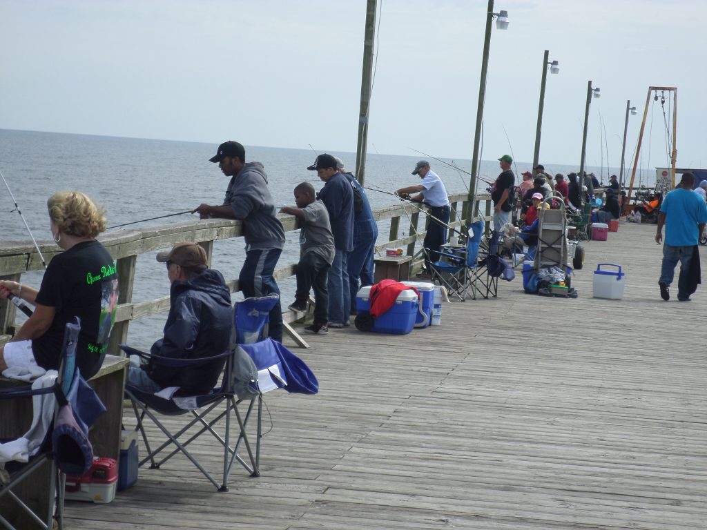 The fishing pier at Carolina Beach is lined with hopeful anglers who want to take home a few spots. 