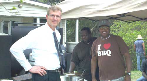 Tony Washington (right) takes the order from a repeat customer who looks for roadside smoke on Fridays.