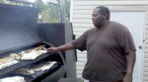 Leo Thomas keeps ribs cooking at the right temperature.