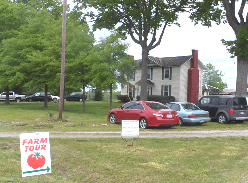 Farm tour sign directs visitors upon arrival to the farm property, which includes the 150-year-old farmhouse in the background.