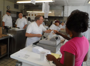 Both sides of the front counter are non-stop with waves of new customers arriving as servers prepare the next orders.