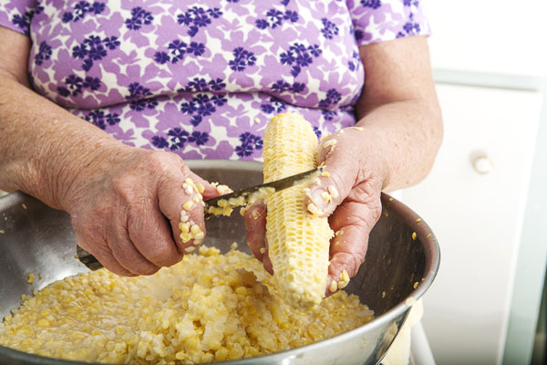 On the second pass, Alice gouges deeper to get every vestige of corn off the cob.