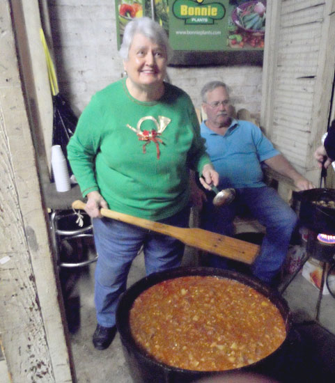 With ladle in hand, Peggy Evans, an employee at Brown’s Hardware, stirs stew as the open house begins.