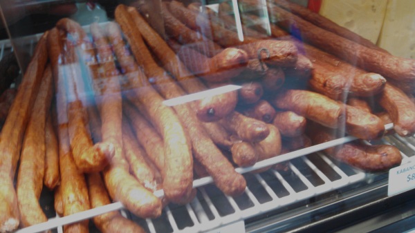 The deli case filled with kielbasa and other imported meats and cheeses: Ham kielbasa, smoked pressed bacon, Braunschweiger, sharp Swiss cheese, & smoked Zamoyski.