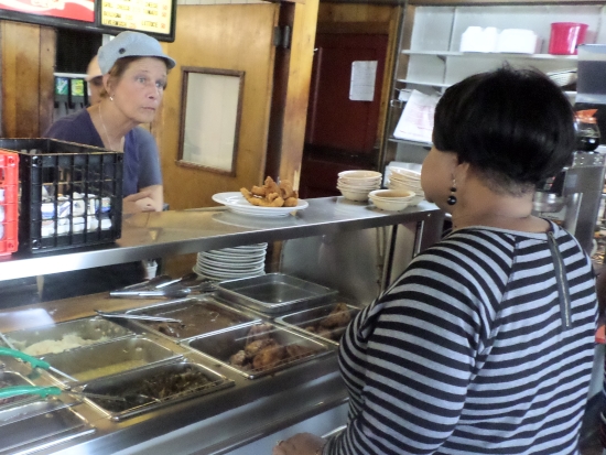 Meats and vegetable daily are ready for serving at the cafeteria-style area.