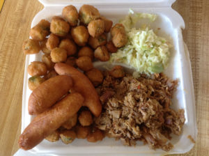 A plate of chopped barbecue with two sides (in this picture, fried okra and coleslaw) and hushpuppies is a popular order. (Ray Linville)